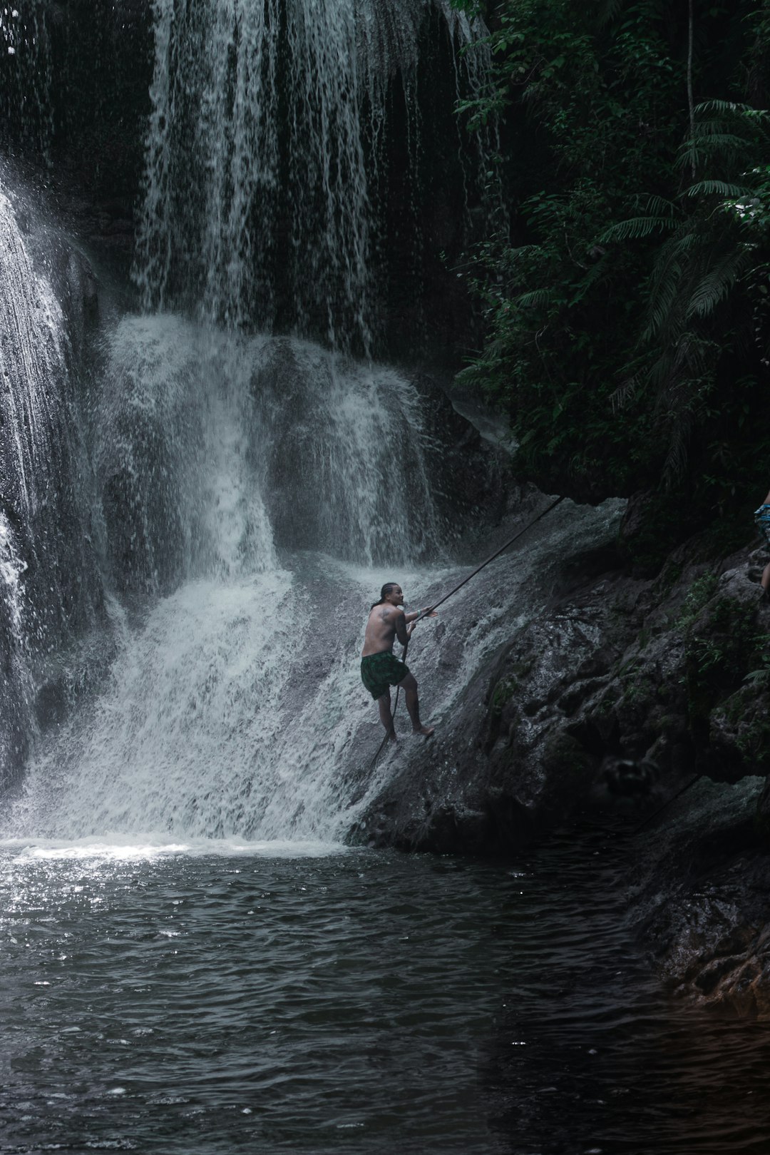 a-man-standing-on-a-rock-in-front-of-a-waterfall-xbq-mhgmqvw