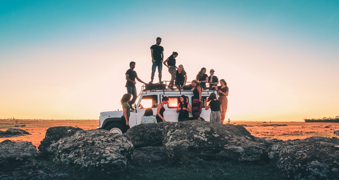 group-of-people-sitting-on-white-car-during-daytime-cj7zhnrqp4w